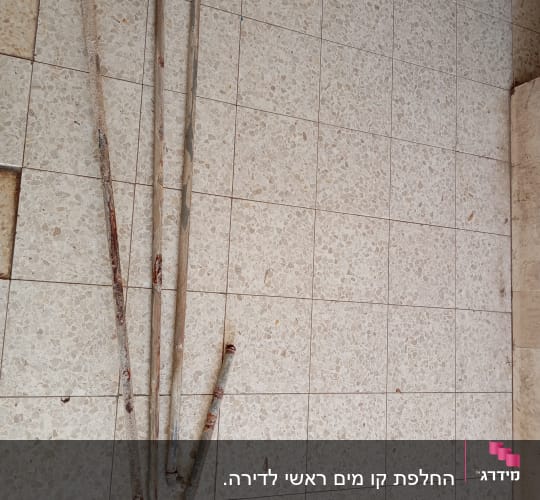 צינורות חלודים מונחים על רצפה מרוצפת